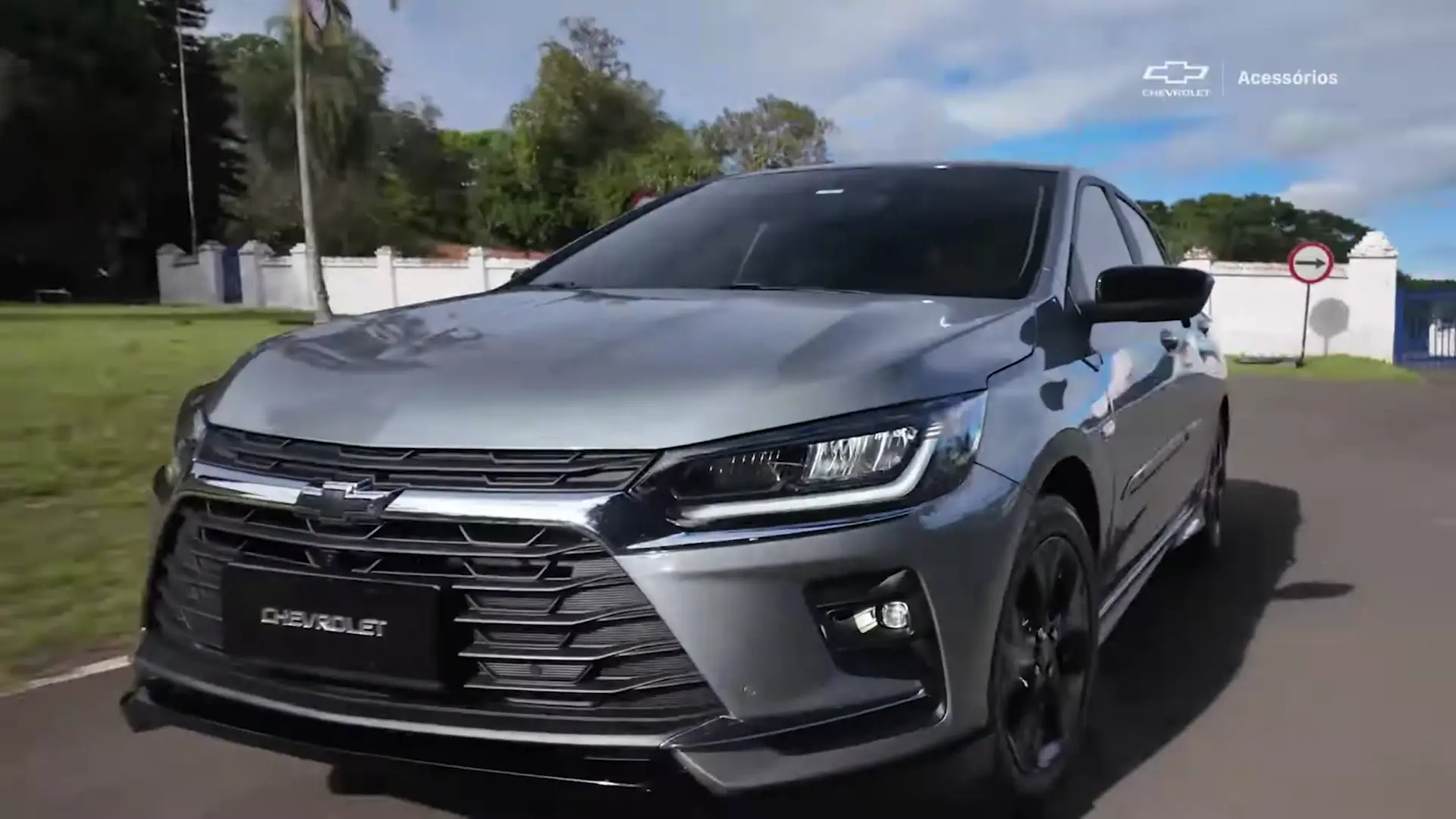 Chevrolet Onix prateado em três quartos dianteiro, parado em pista de asfalto